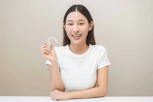 Dentist in Aubrey TX showing Invisalign clear aligners to a patient during a smile consultation